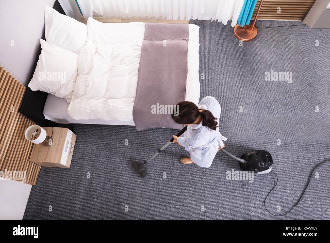 Housekeeper Cleaning Carpet With Vacuum Cleaner Stock Photo Alamy
