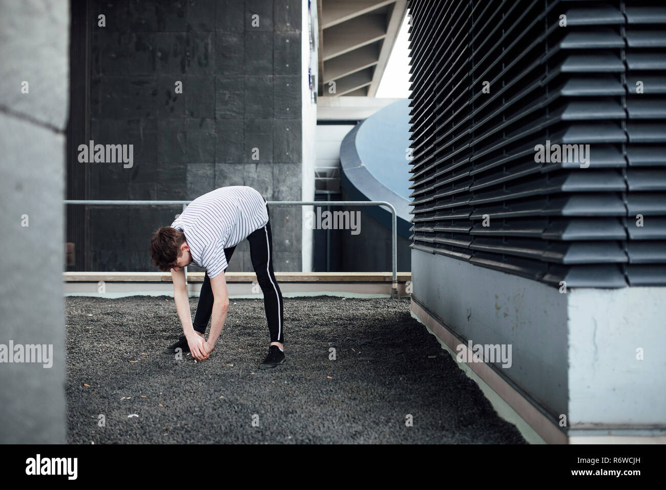 Freerunner Stretching on a Rooftop Stock Photo