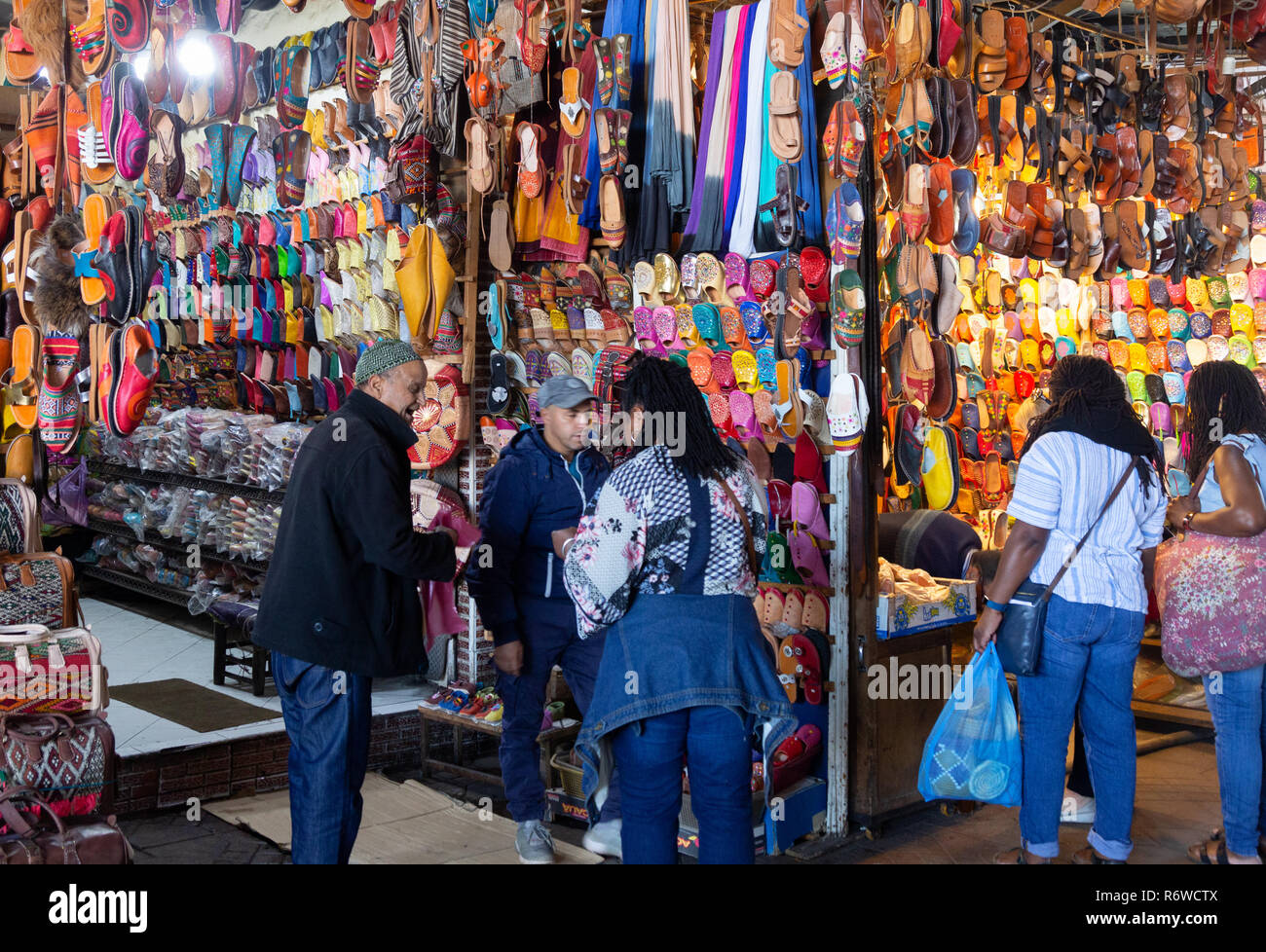 Marrakech souk - Women shopping in the medina, Marrakech, buying colourful shoes and slippers, Marrakesh, Morocco Africa Stock Photo