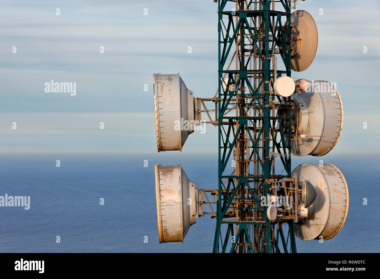 Detail of a telecommunications antenna with the sea in the background. Stock Photo