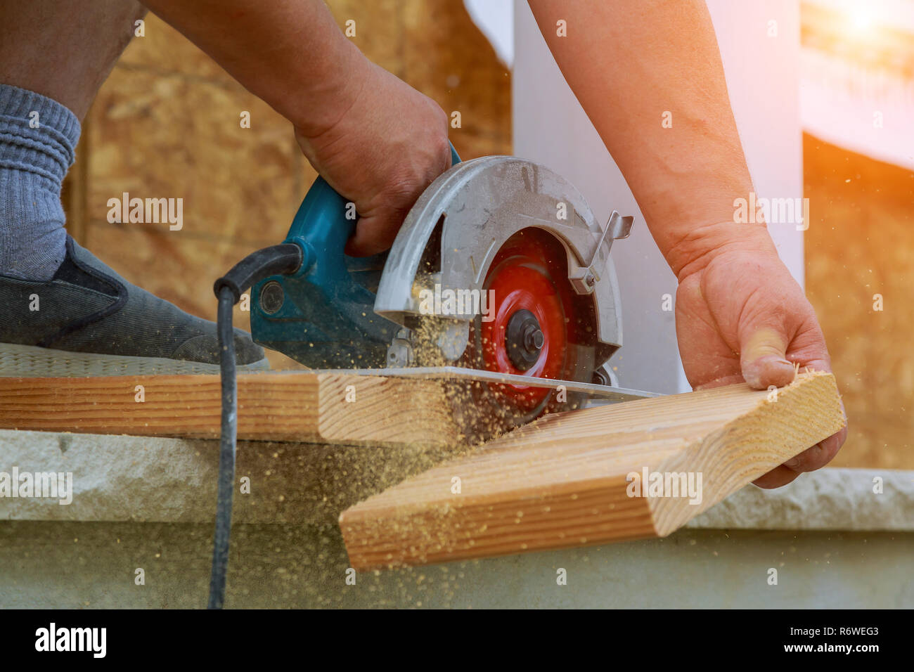 https://c8.alamy.com/comp/R6WEG3/building-contractor-worker-using-hand-held-worm-drive-circular-saw-to-cut-boards-on-a-new-home-constructiion-project-R6WEG3.jpg