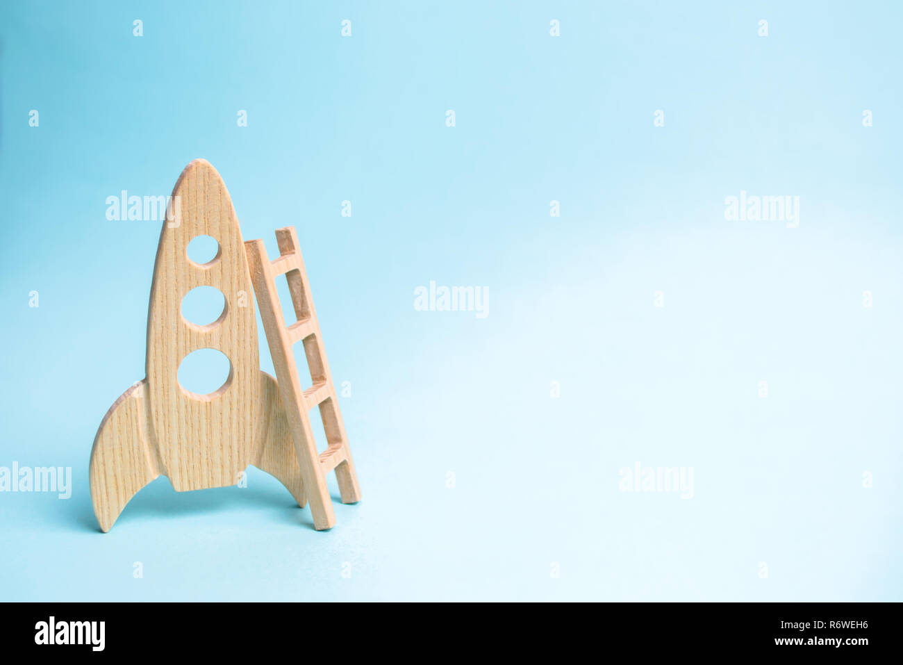 Rocket and ladder on a blue background. The rocket is ready to take off into space. The concept of a startup, education and the desire to research. Sp Stock Photo