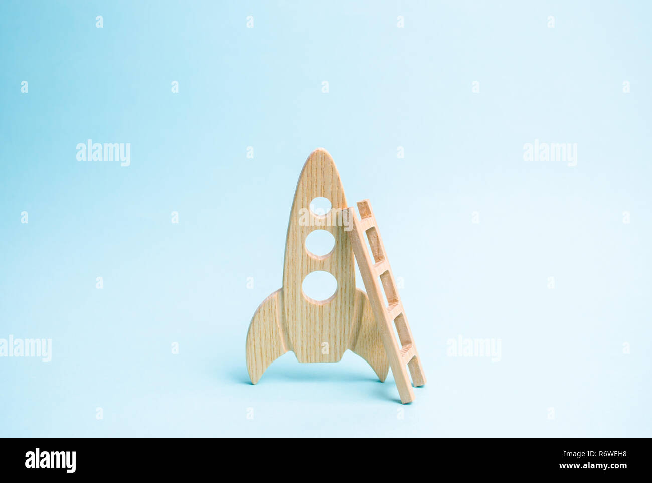 Rocket and ladder on a blue background. The rocket is ready to take off into space. The concept of a startup, education and the desire to research. Sp Stock Photo