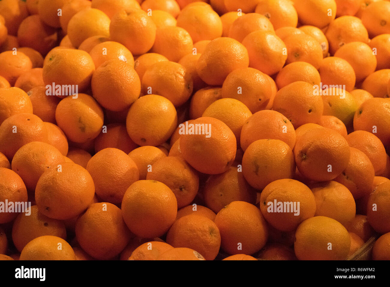Bulk oranges stored in a bin at an open air market Stock Photo