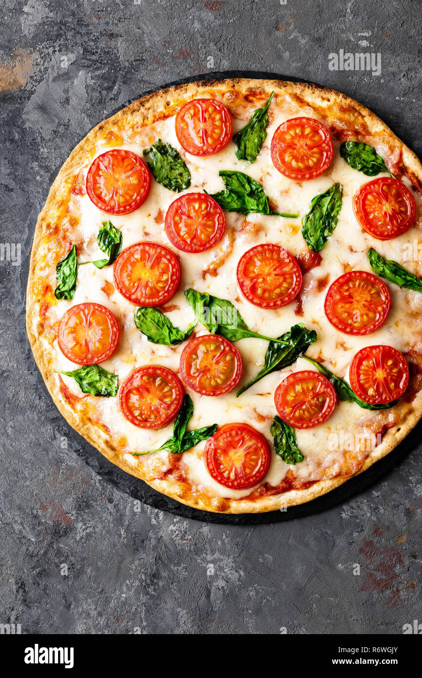 Pizza Margherita with mozzarella cheese, basil and tomatoes Traditional