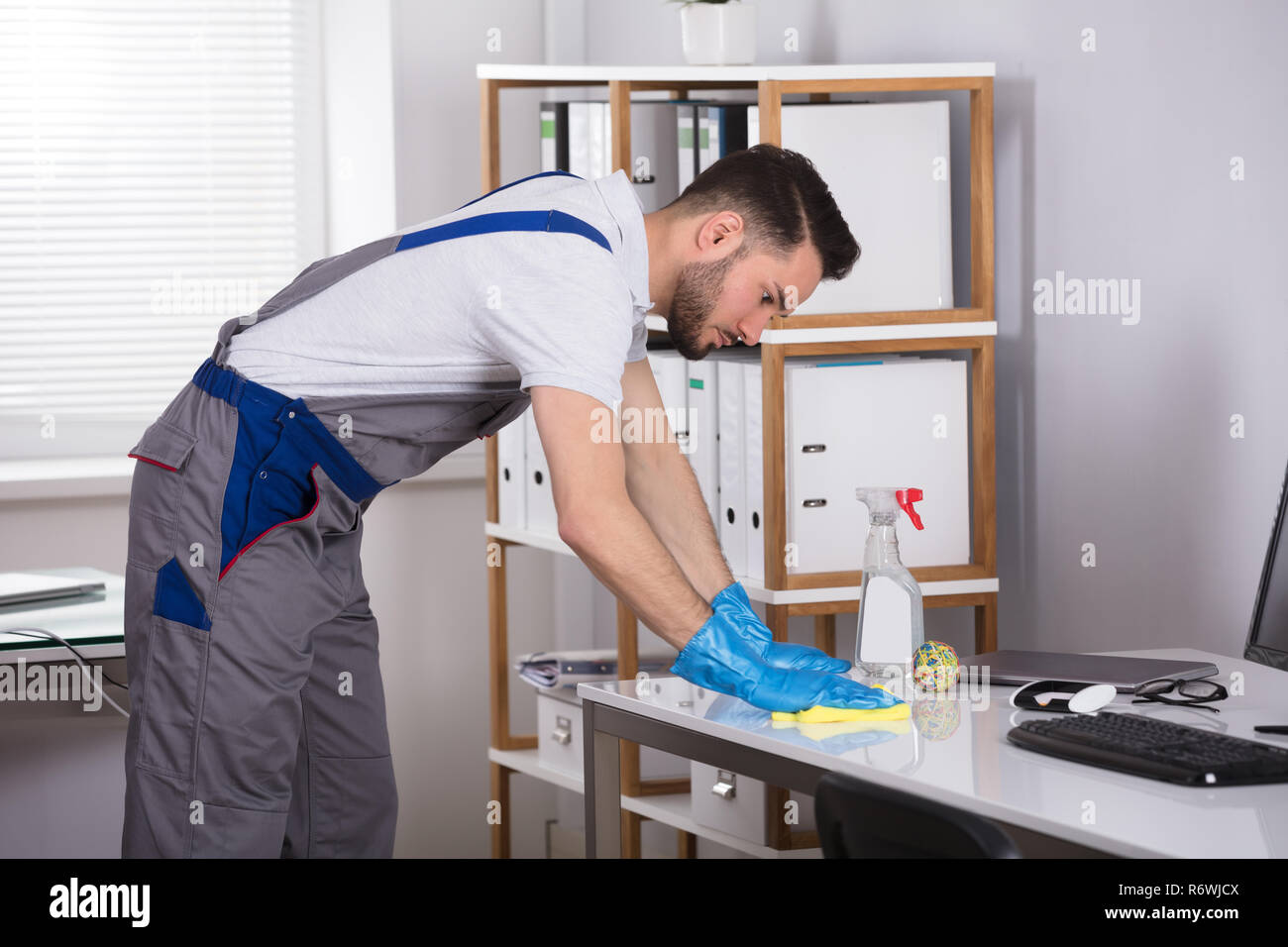 Man Cleaning Desk In Office Stock Photo Alamy