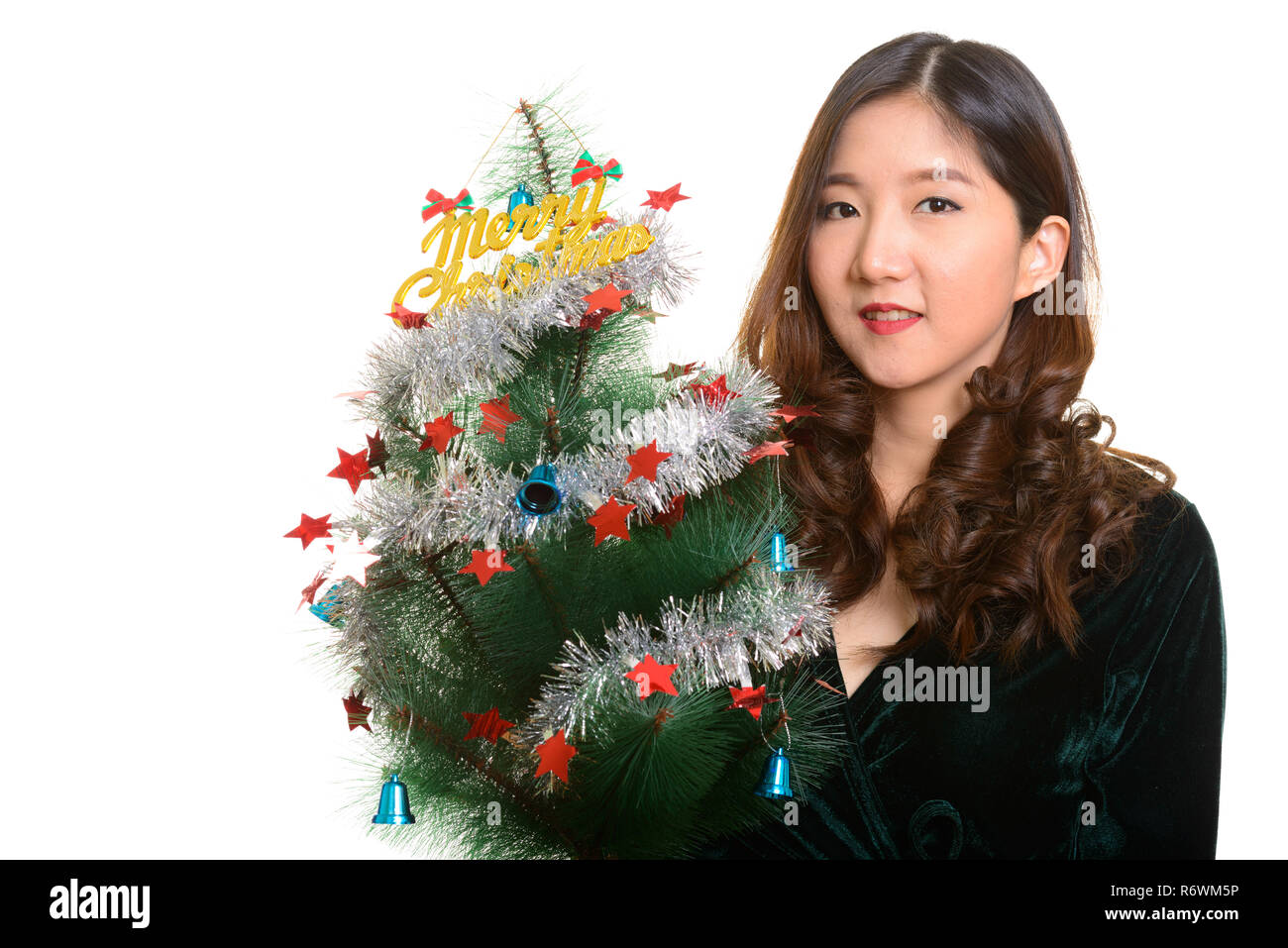 Young happy Asian woman holding Merry Christmas tree Stock Photo