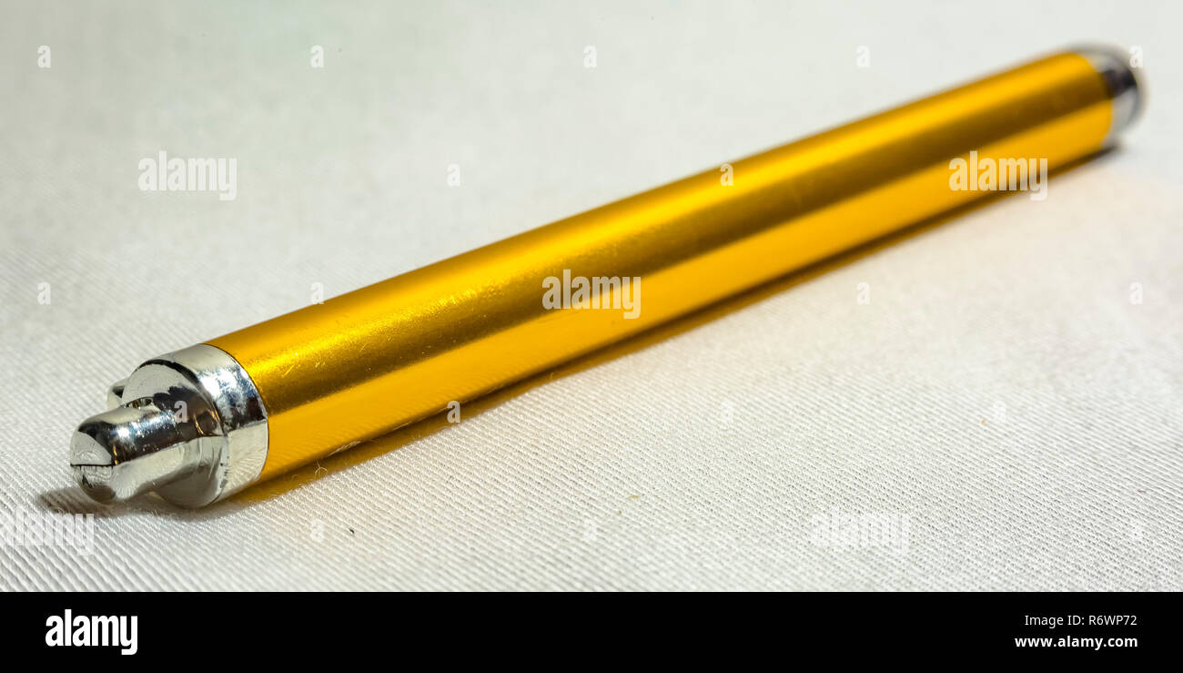 Yellow stylus pen on a white textured surface Stock Photo