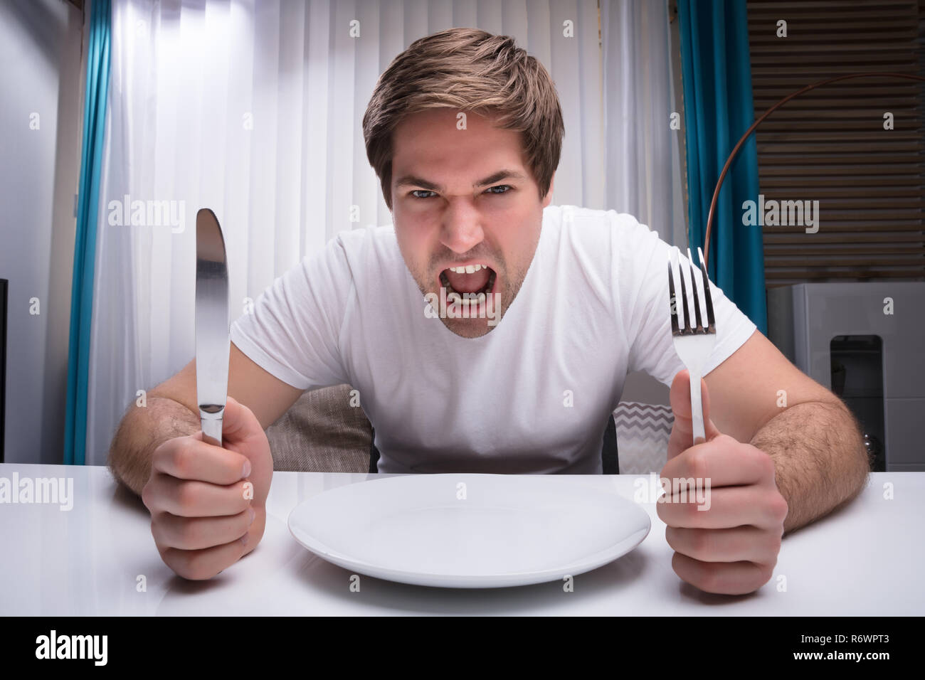 Angry Man Holding Knife And Fork Stock Photo Alamy