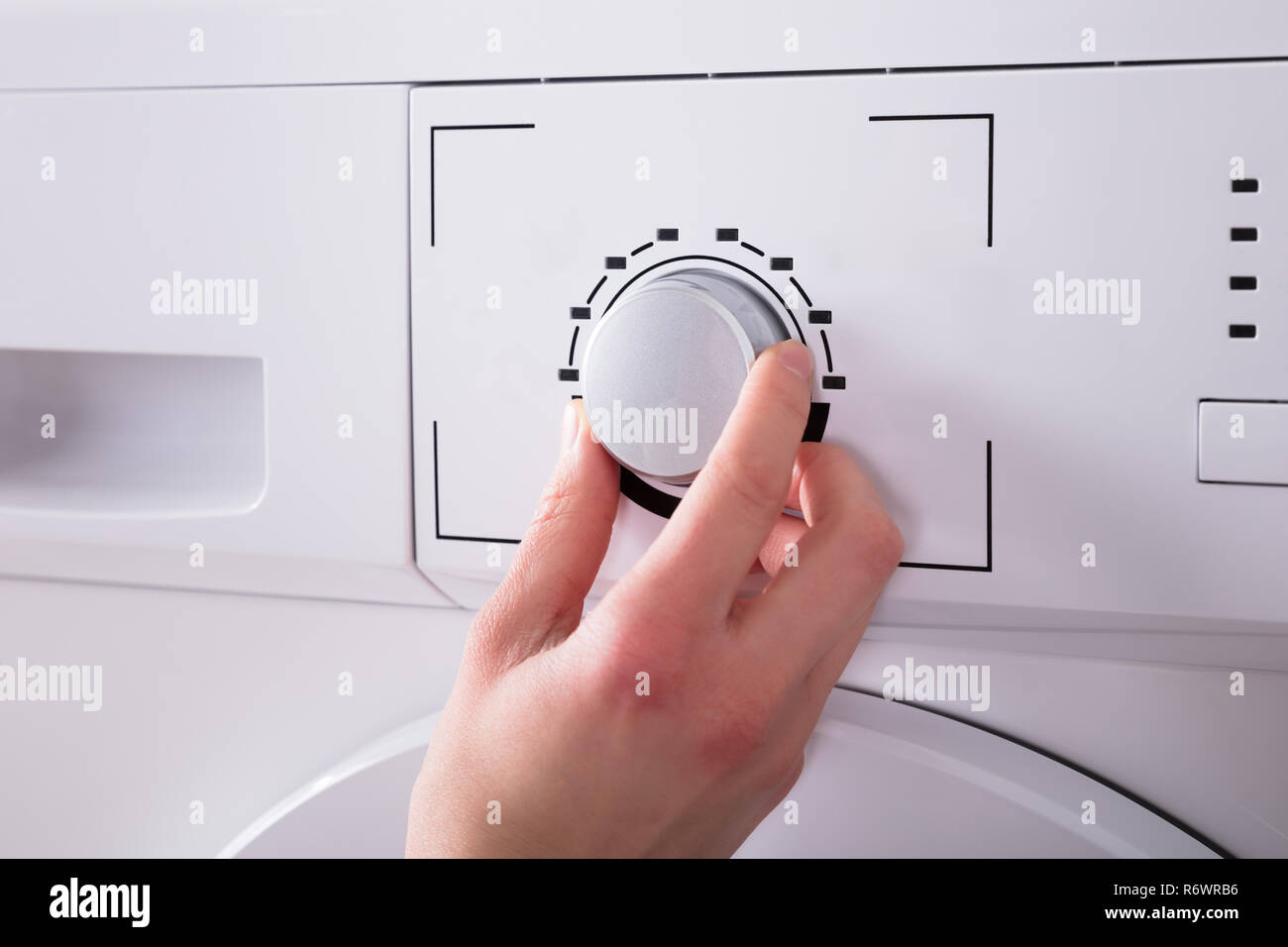 Person Turning Button Of Washing Machine Stock Photo Alamy