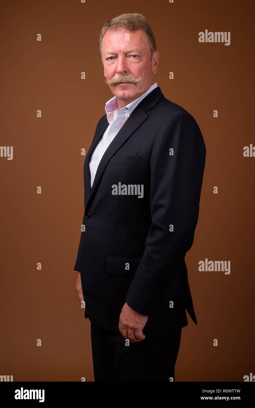Handsome senior businessman with mustache wearing suit Stock Photo