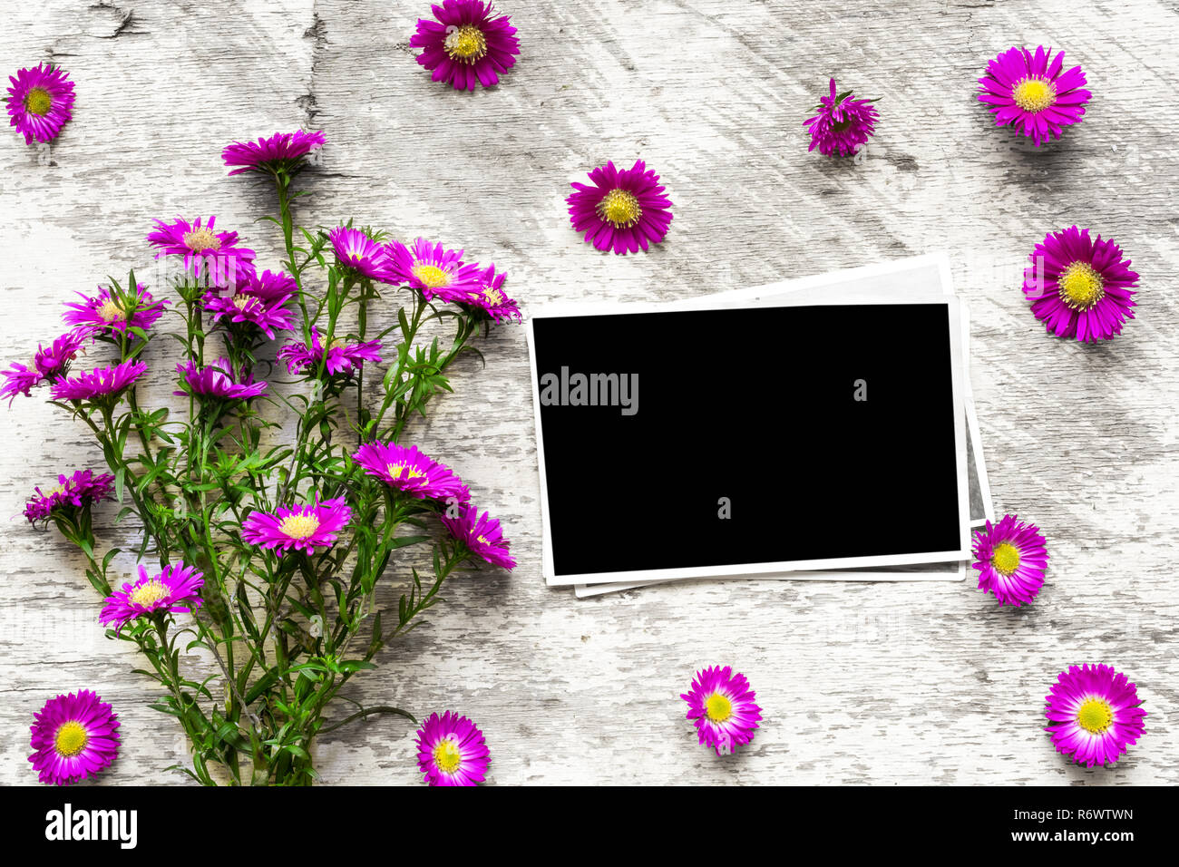 blank photo frame with pink flowers bouquet to put your picture on white wooden background .top view. mock up. flat lay Stock Photo