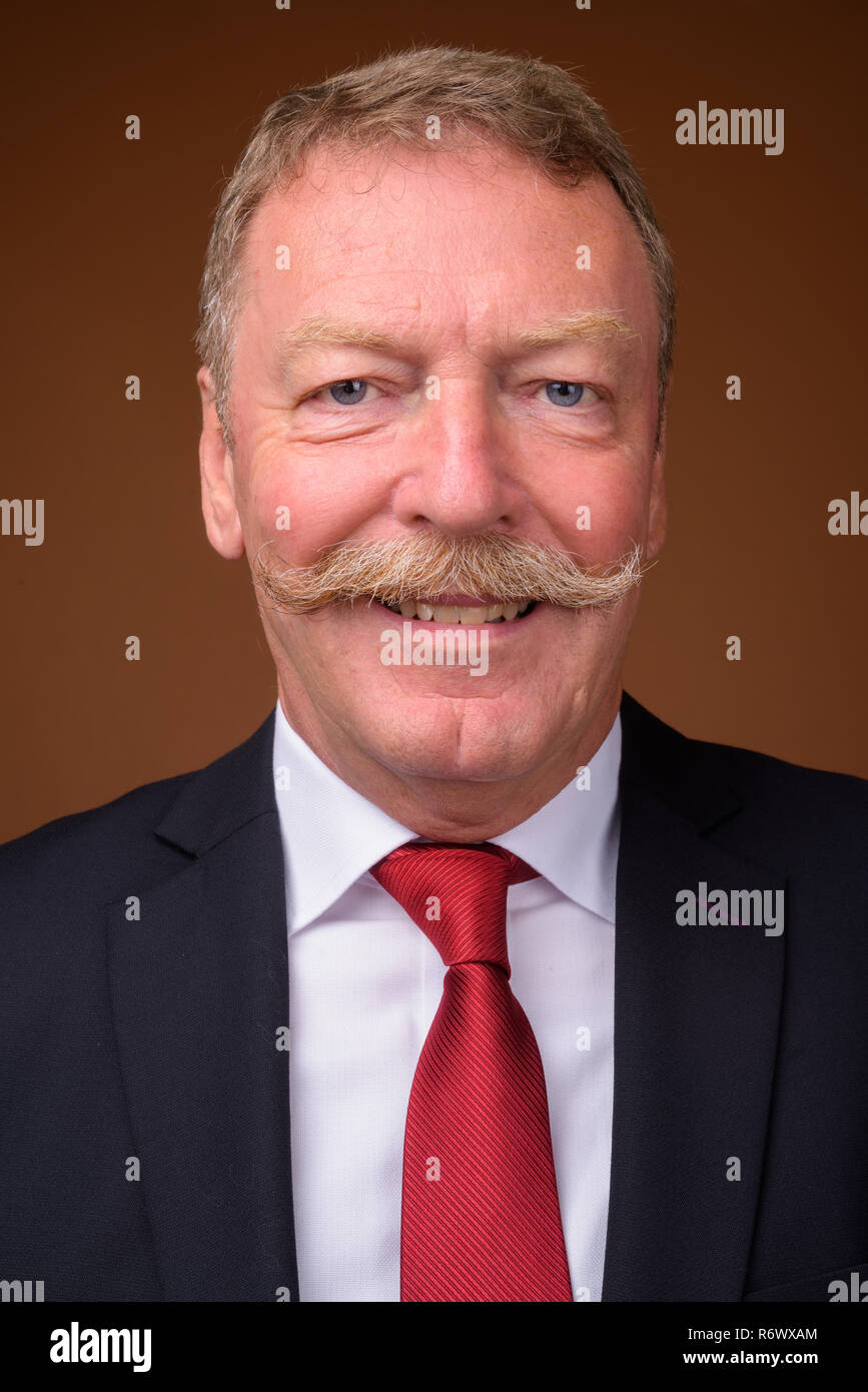 Face of happy senior businessman wearing suit and tie while smiling ...