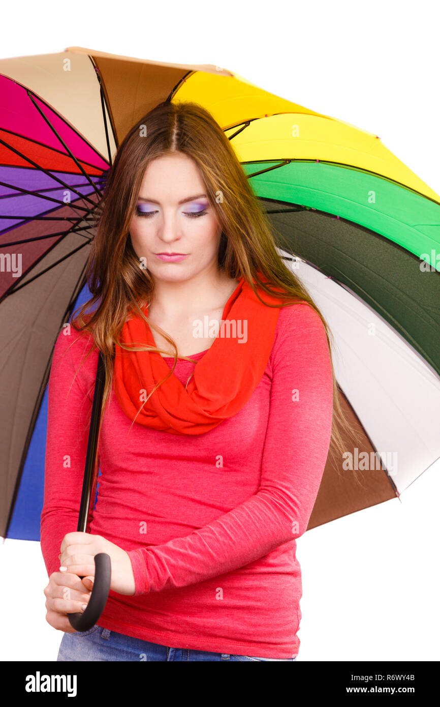 Woman fashionable rainy girl in red clothing standing under colorful