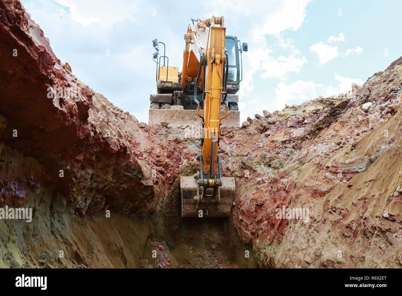 Excavator digging a trench for the pipeline. Excavation Stock Photo