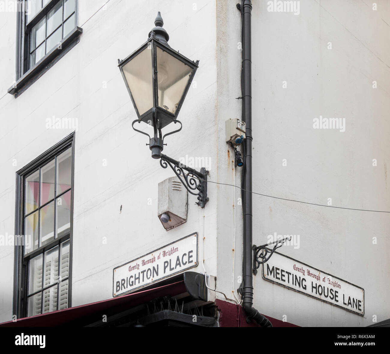 Street name signs on the corner of Brighton Place and Meeting House Lane in the historic town of Brighton, East Sussex, UK Stock Photo