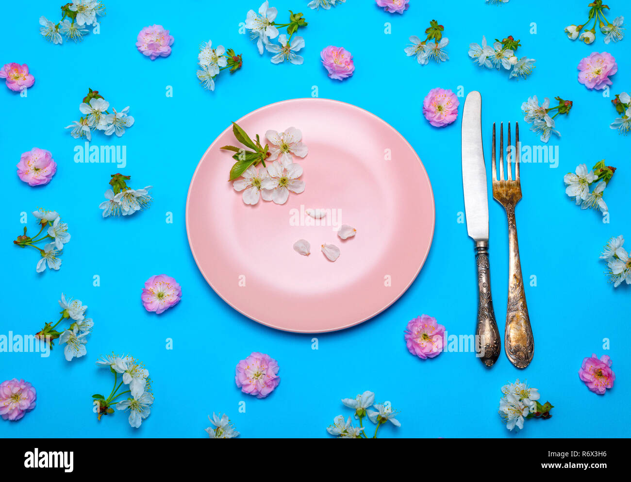 empty round pink ceramic plate and a vintage knife with a fork Stock ...