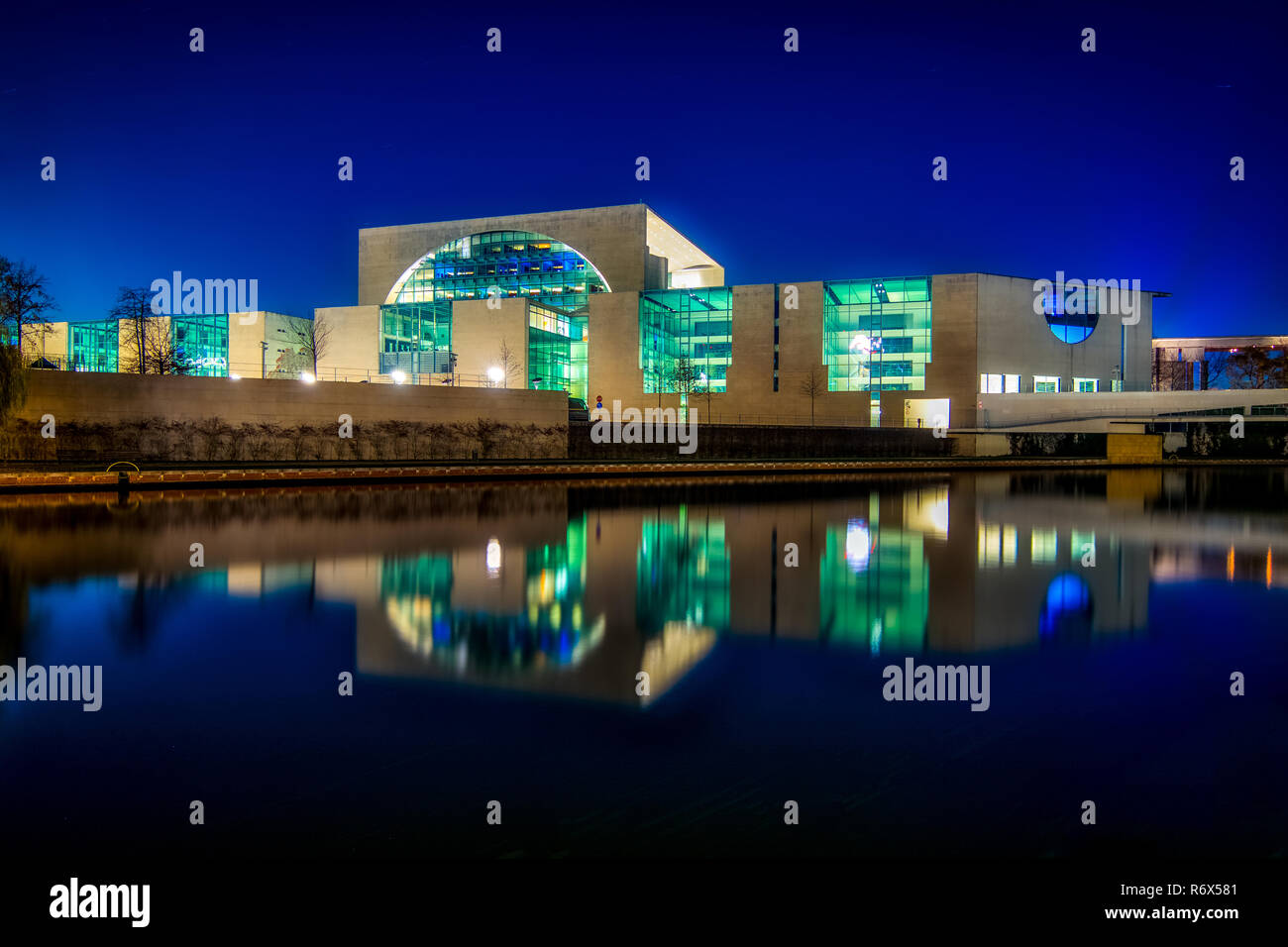 Night shot of the Bundeskanzler amt (chancellor office) seen from the river Spree with reflections in water Stock Photo