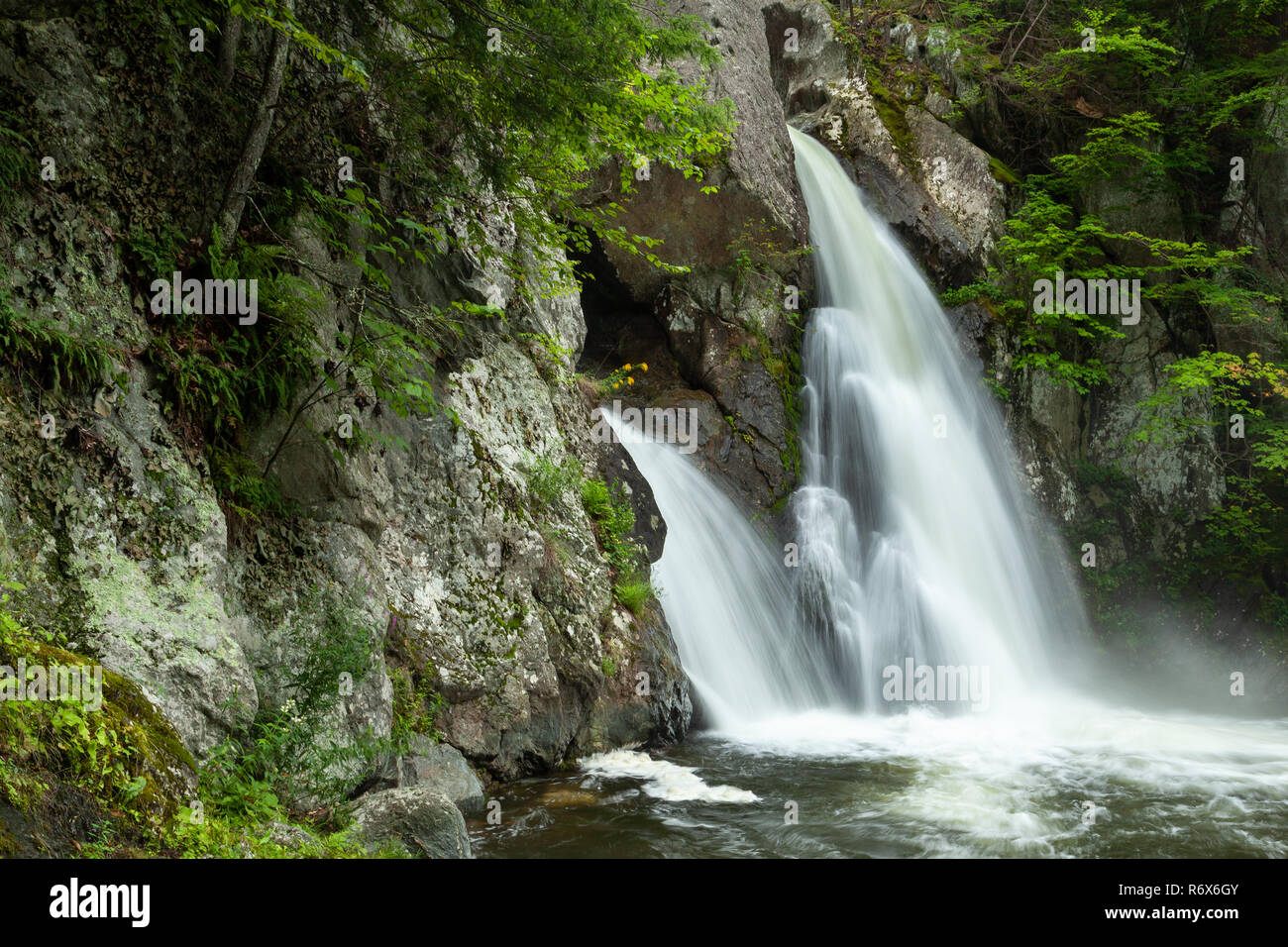 Jagged rocks and cliffs surrounding the pool and waterfall along Bash