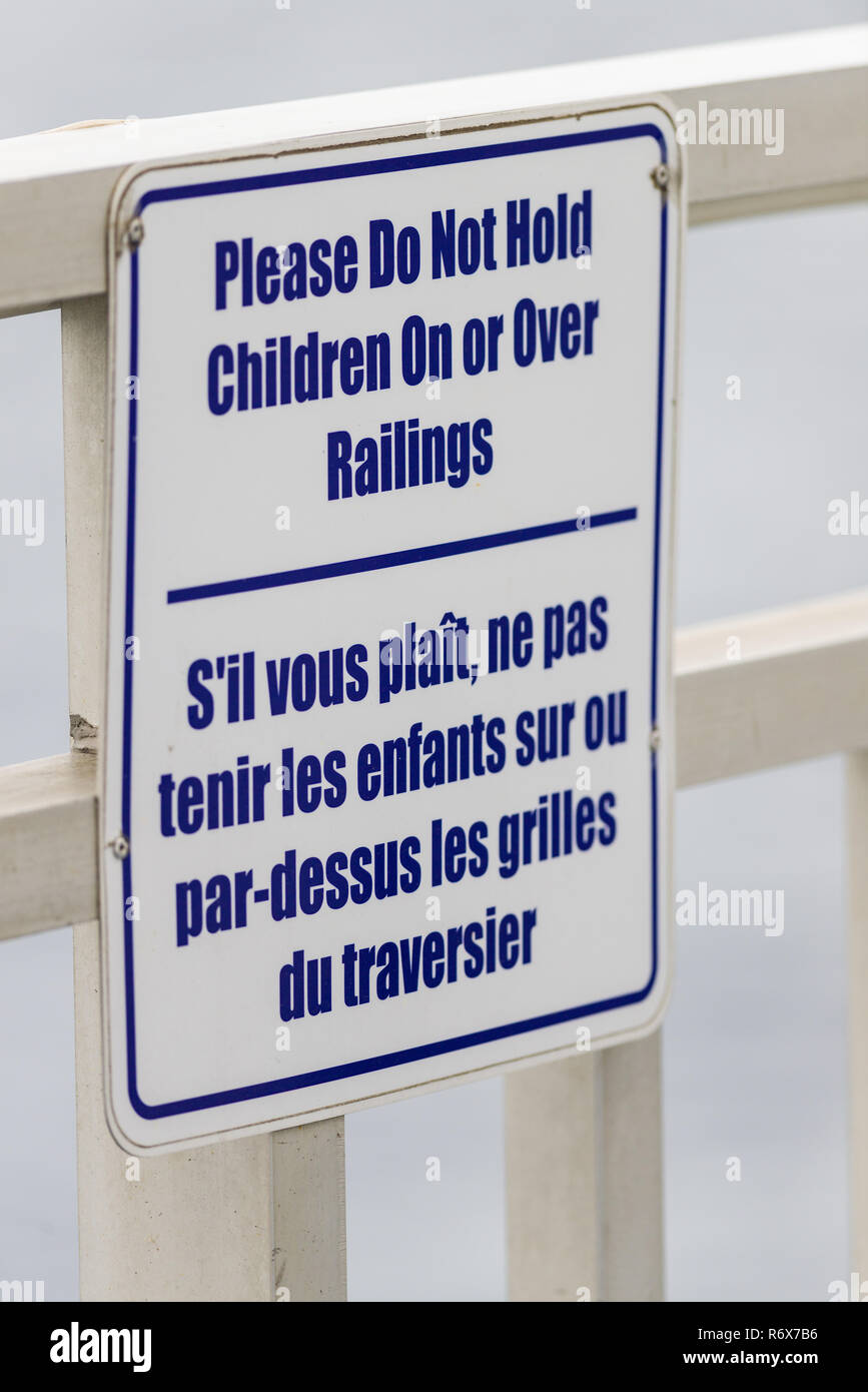 A sign on the Chi-Cheemaun ferry stating 'Please Do Not Hold Children On or Over Railings' in English and French Stock Photo