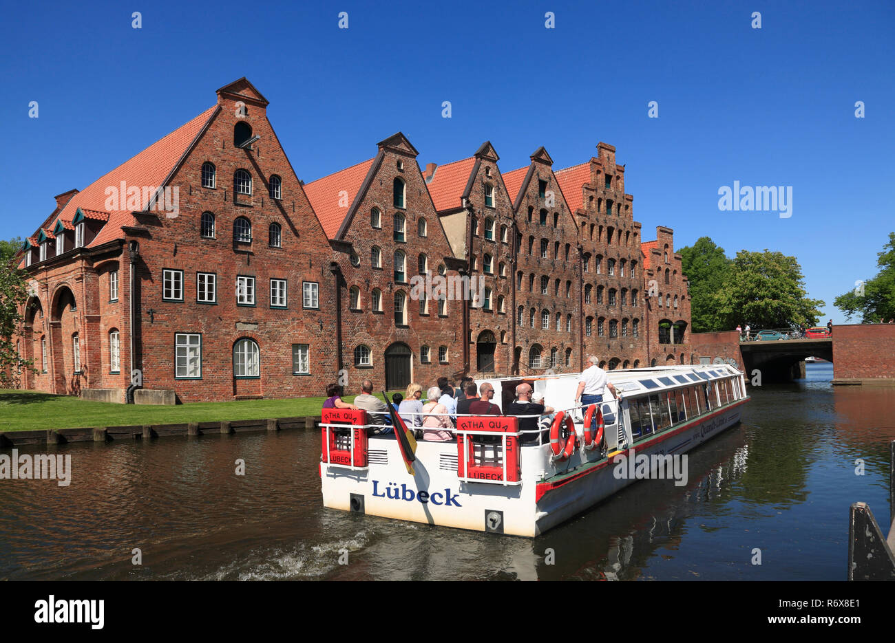 Tourist sightseeing ship in front of historic salt storages at river Trave, Lübeck, Luebeck, Schleswig-Holstein, Germany, Europe Stock Photo