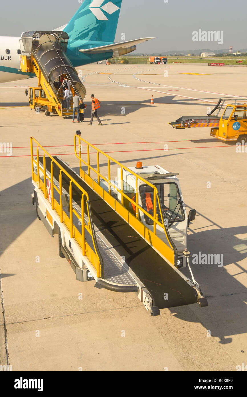 Ground handling equipment including luggage loader vehicles at Verona airport, Italy Stock Photo