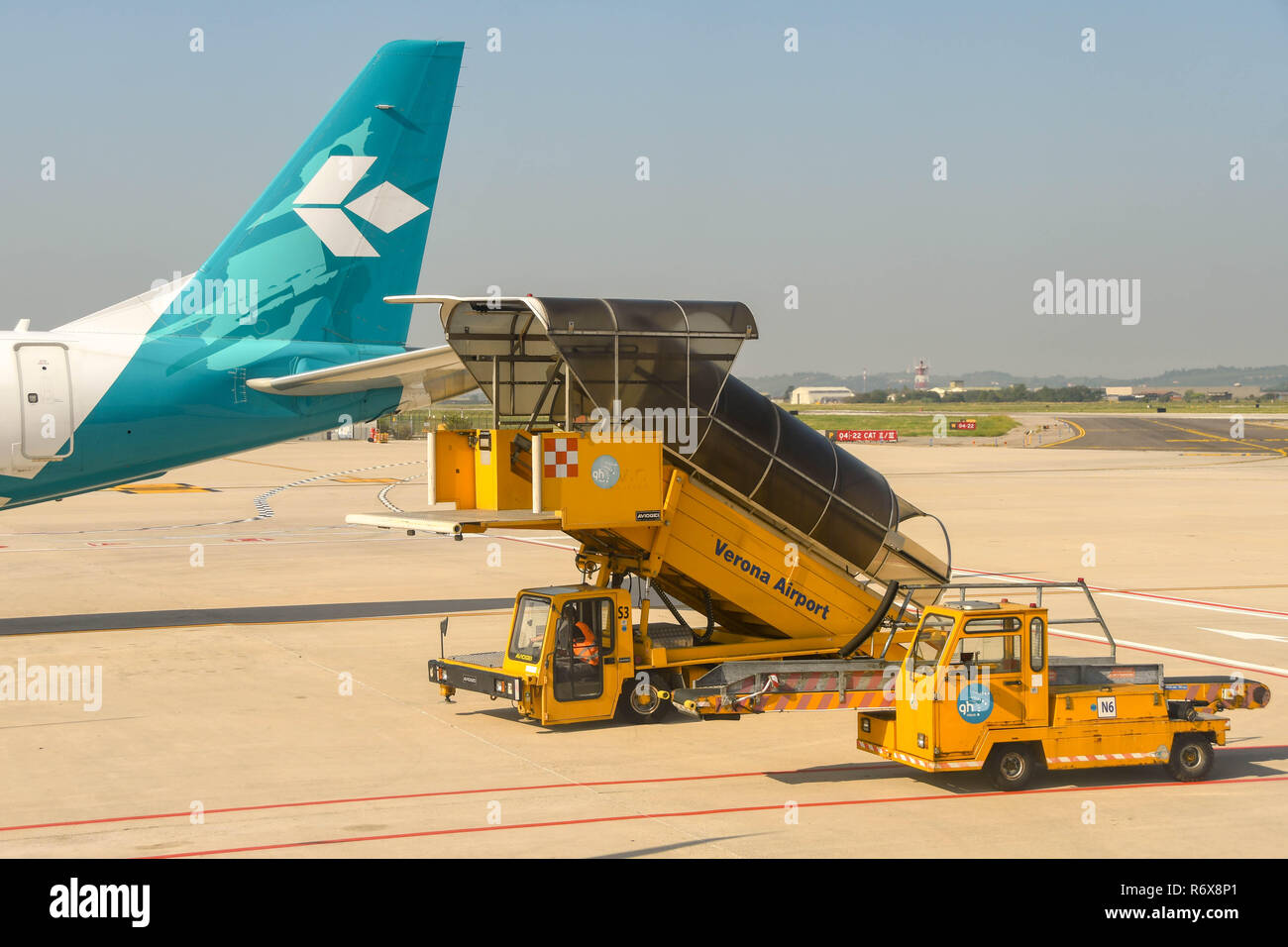 Ground handling equipment including luggage loader vehicles at Verona airport, Italy Stock Photo