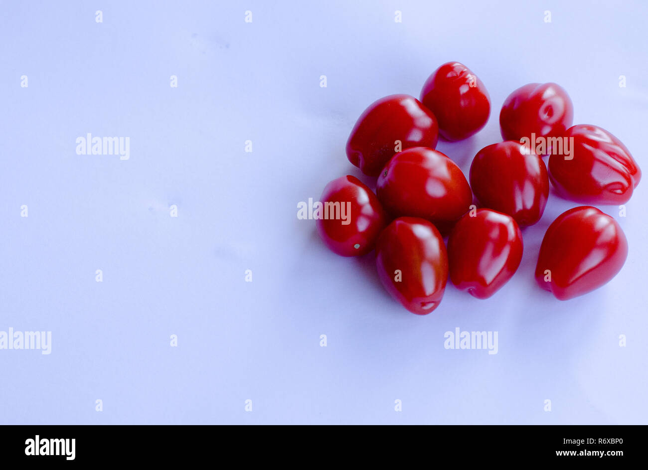 Red small cherry tomatoes in group on white background Stock Photo