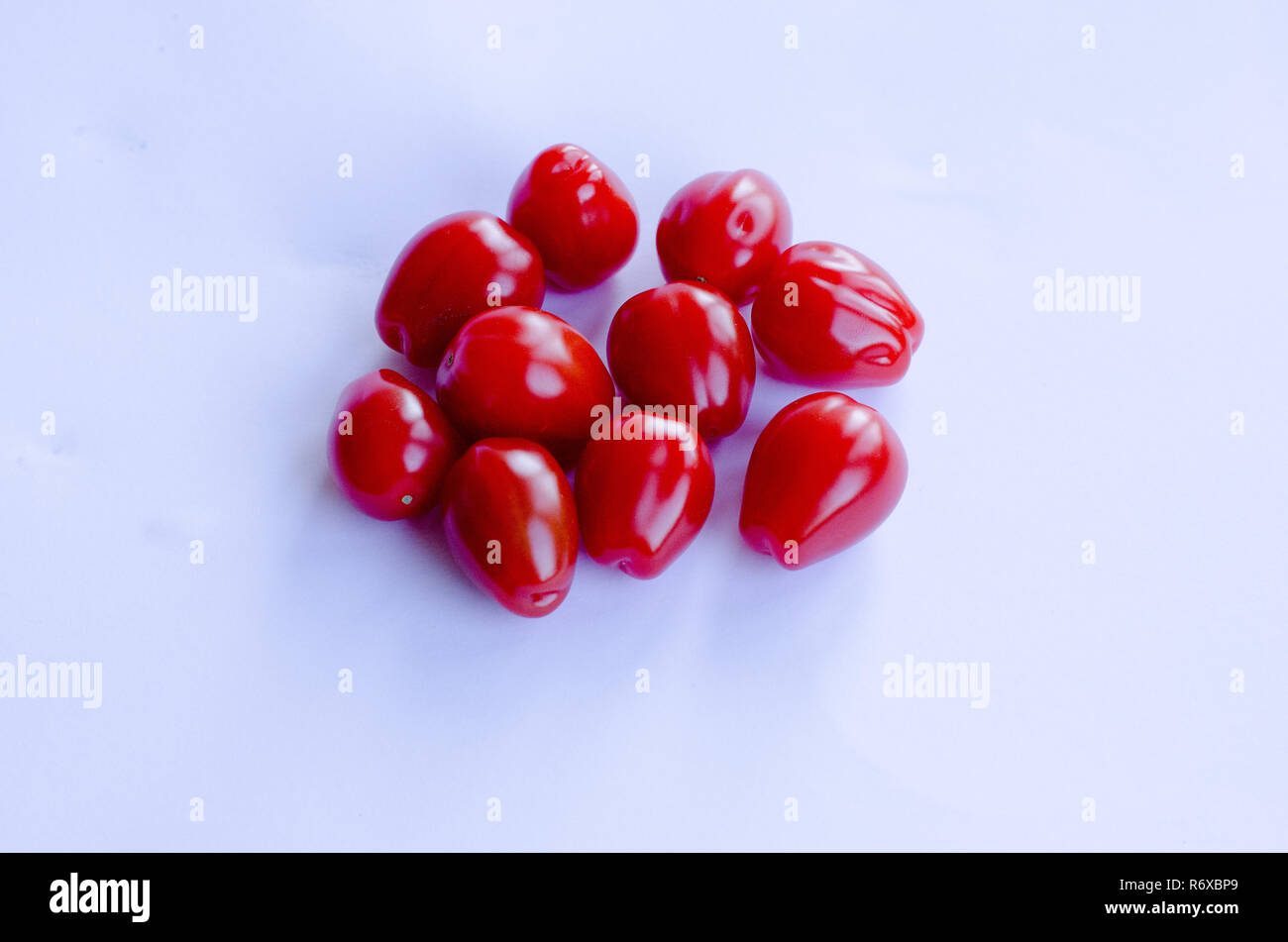 Red small cherry tomatoes in group on white background Stock Photo - Alamy