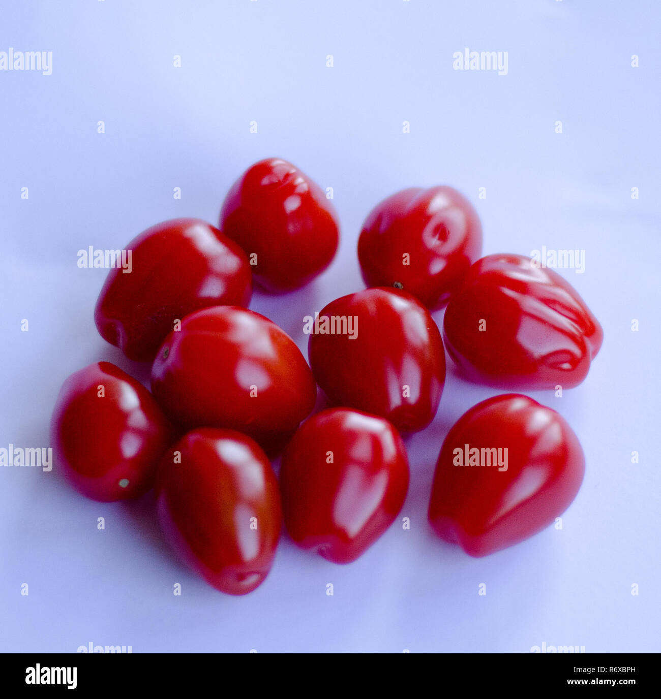 Red small cherry tomatoes in group on white background Stock Photo - Alamy