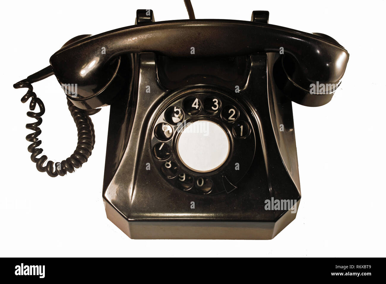 This kind of bakelite telephone was produced in the 1955 in Switzerland. It has a classical dial. Isolated on white background. Stock Photo