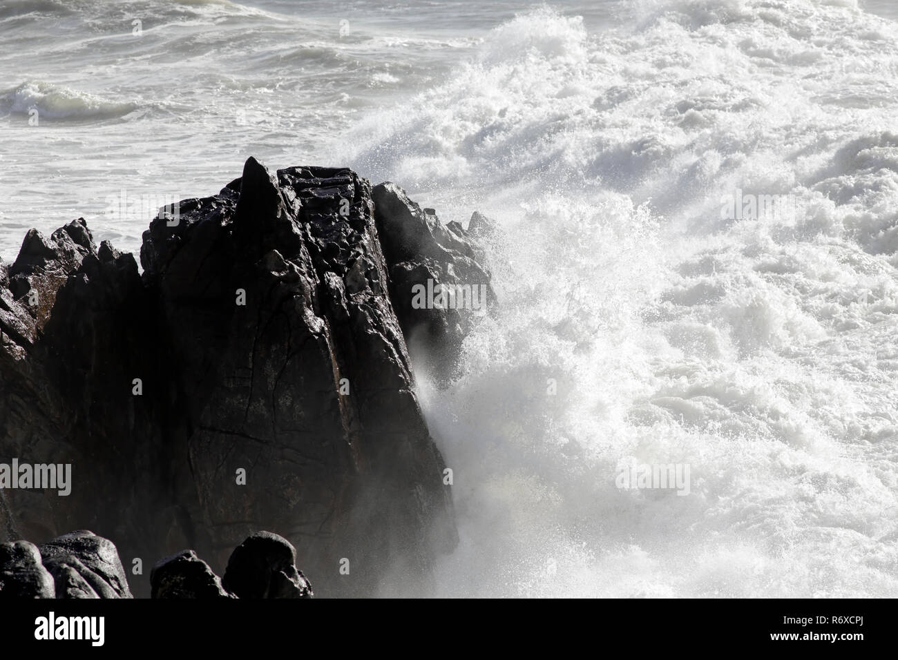 Small cape of Sao Paio about to be hit by a big stormy wave, north of Portugal Stock Photo