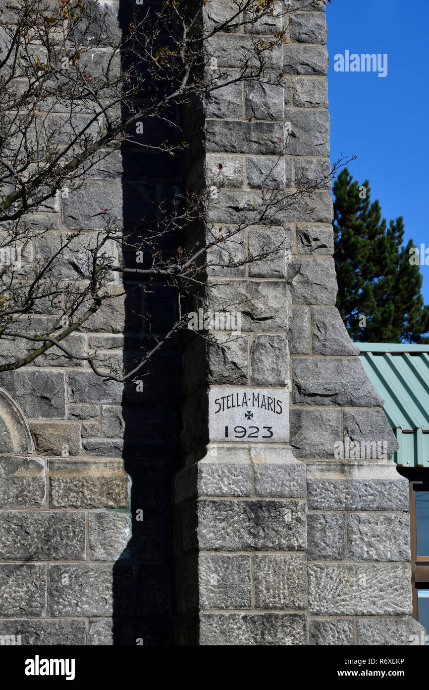 A corner stone block in the Stella Maris Roman Cathloic church telling the building date and a medieval, cross in Saint John New Brunswick Canada Stock Photo
