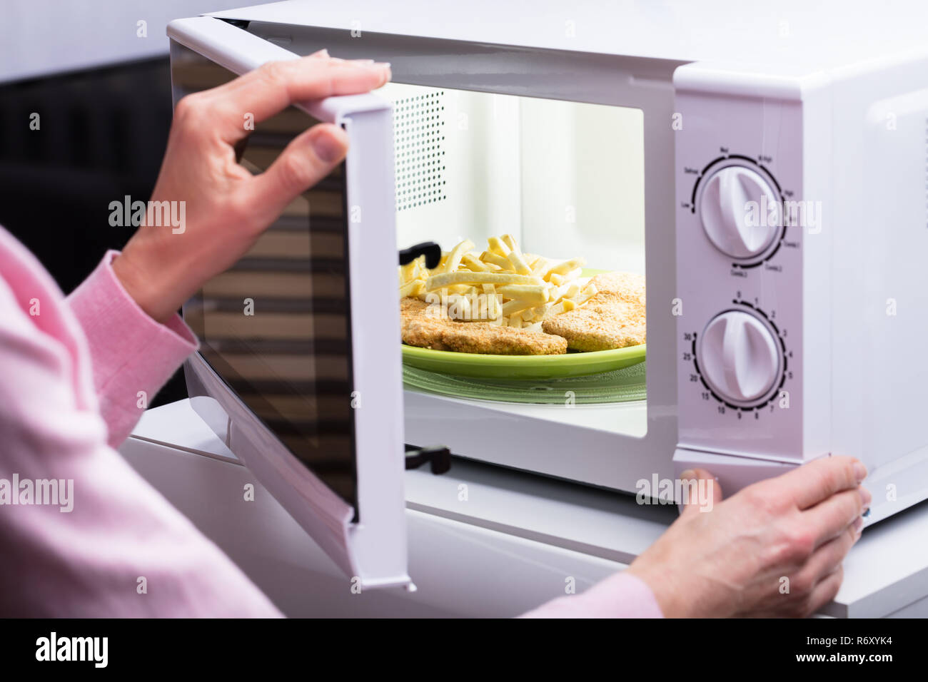 https://c8.alamy.com/comp/R6XYK4/woman-heating-food-in-microwave-R6XYK4.jpg