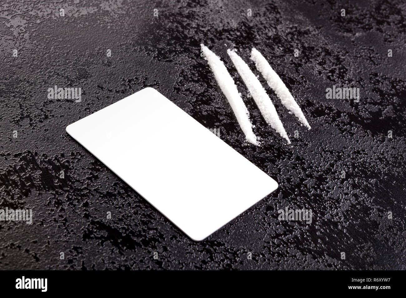 Cocaine lines with card on dark surface Stock Photo - Alamy