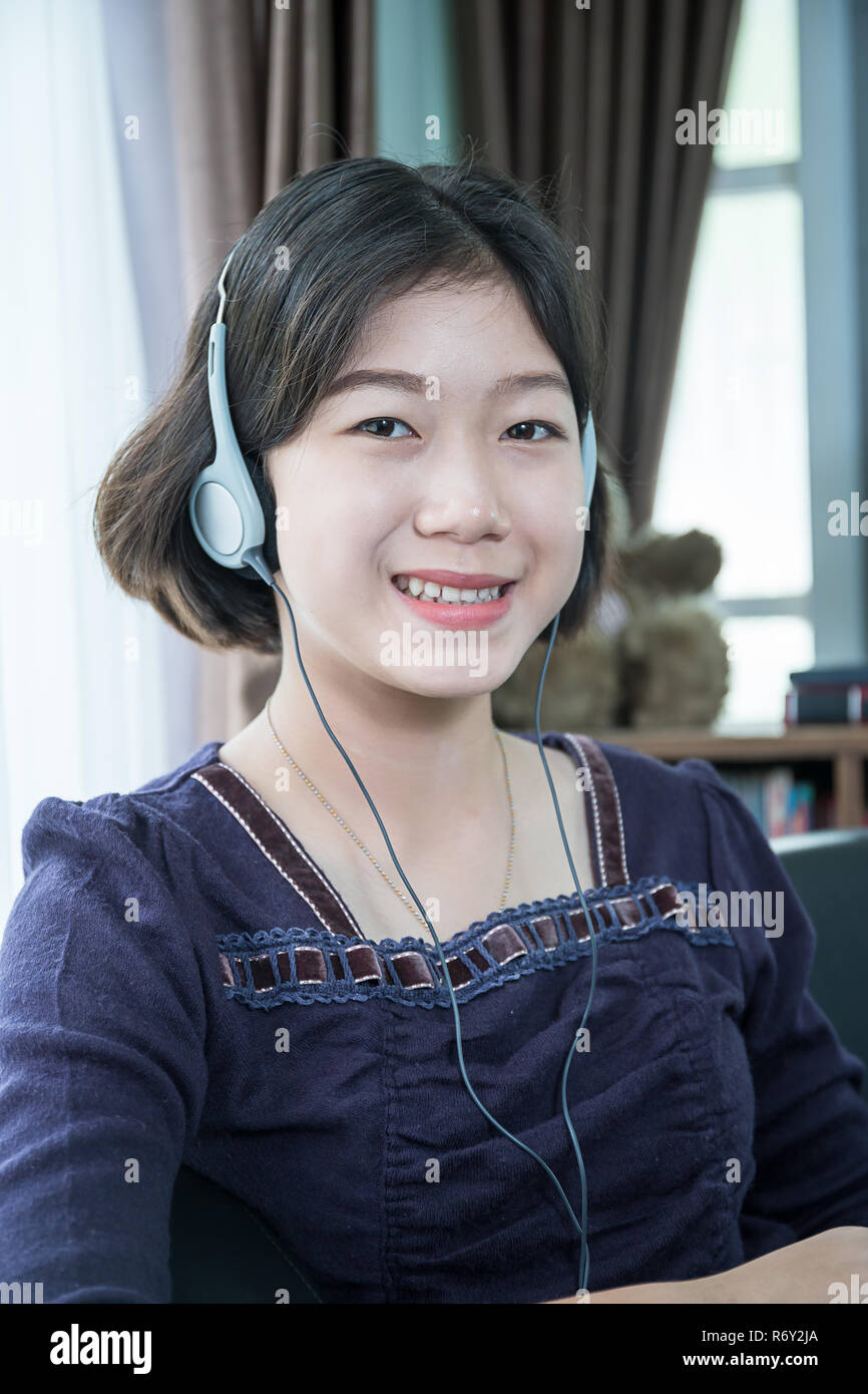 Young Asian Woman Short Hair Listening Music In Living Room Stock