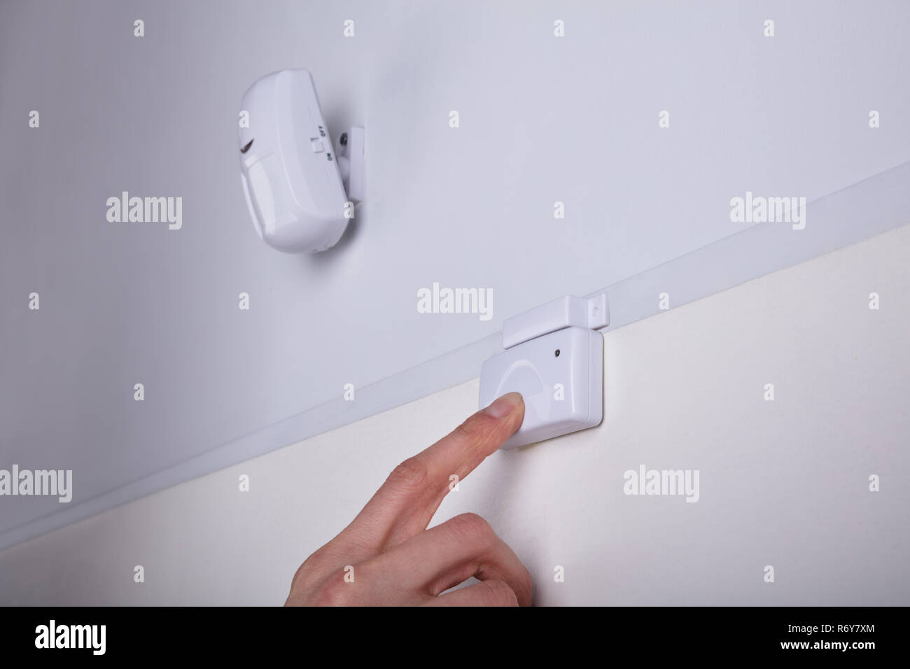 Person Pressing Security System Door Sensor Stock Photo