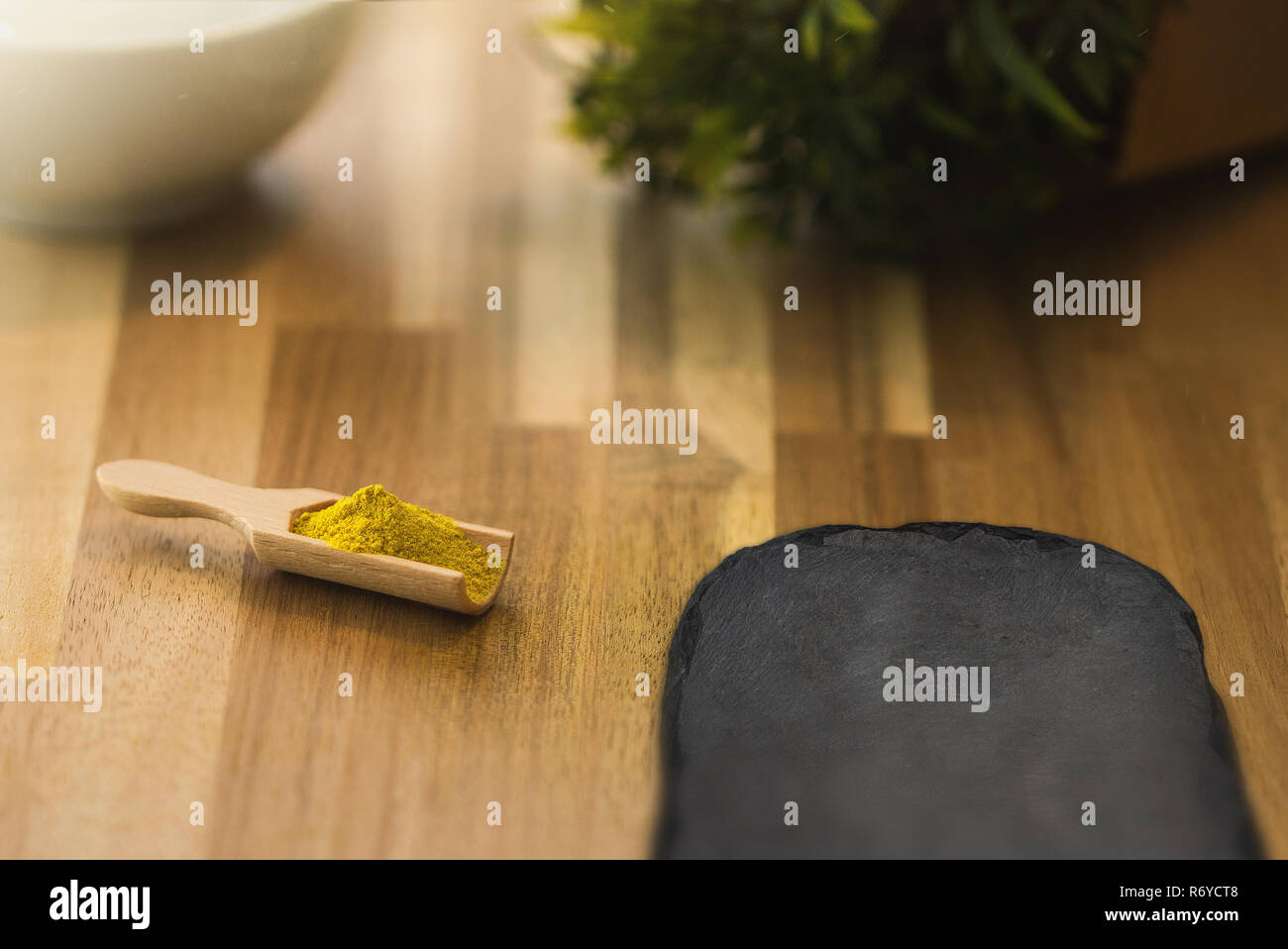 Curry spice powder and herbs on a wooden spoon. Ingredients for cooking and seasoning. Stock Photo