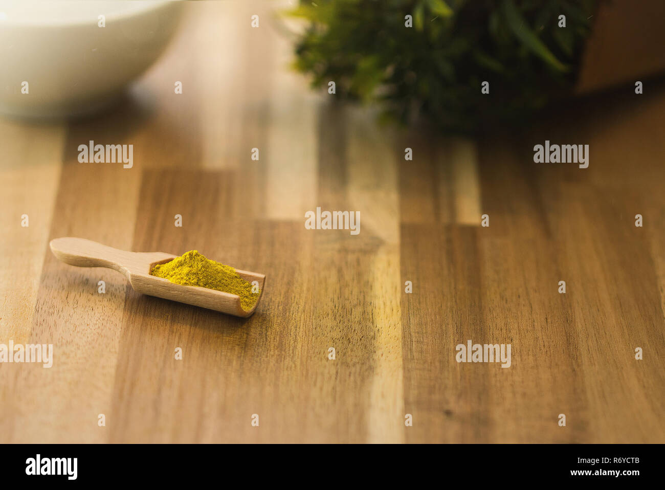 Curry spice powder and herbs on a wooden spoon. Ingredients for cooking and seasoning. Stock Photo