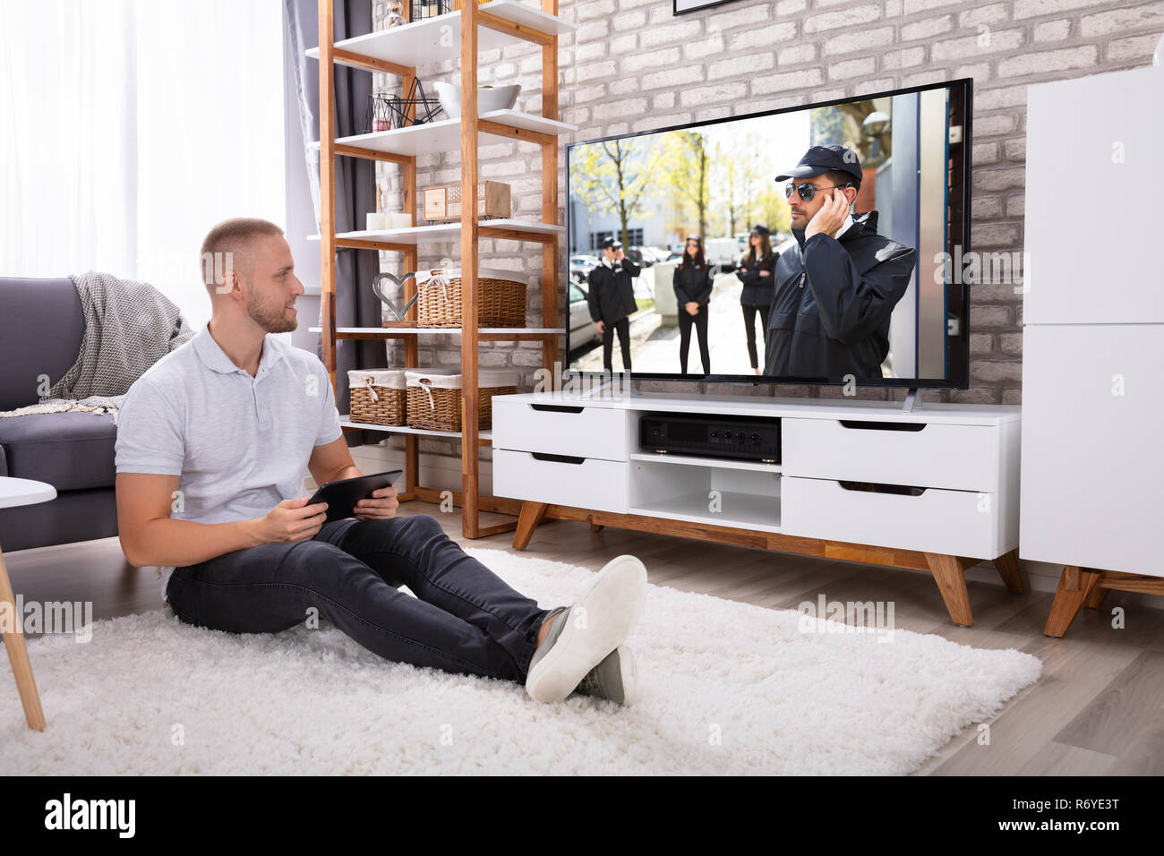 Man Streaming Television Channel Through Wireless Connection On Digital Tablet Stock Photo