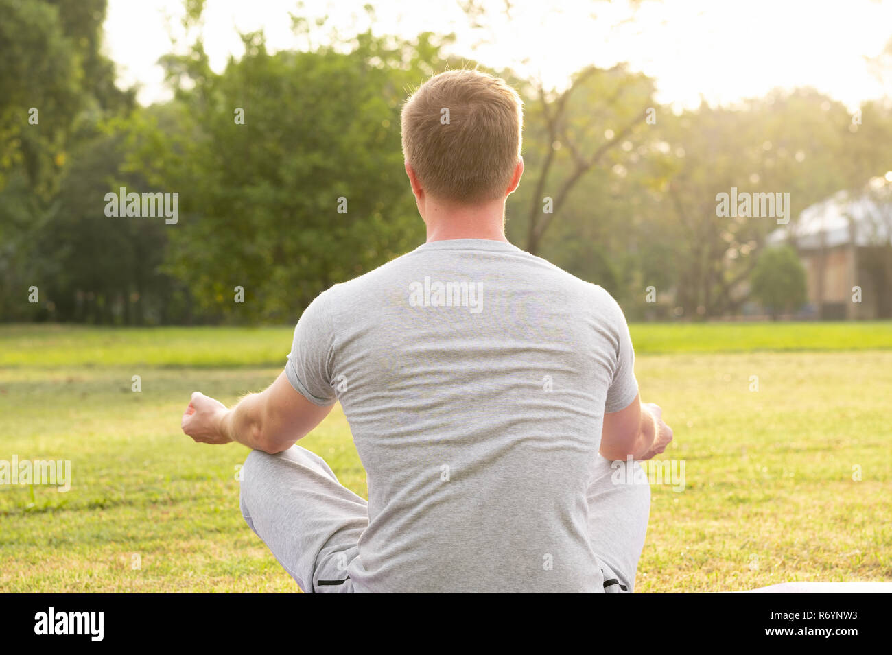 Rear view man meditating sitting hi-res stock photography and images ...