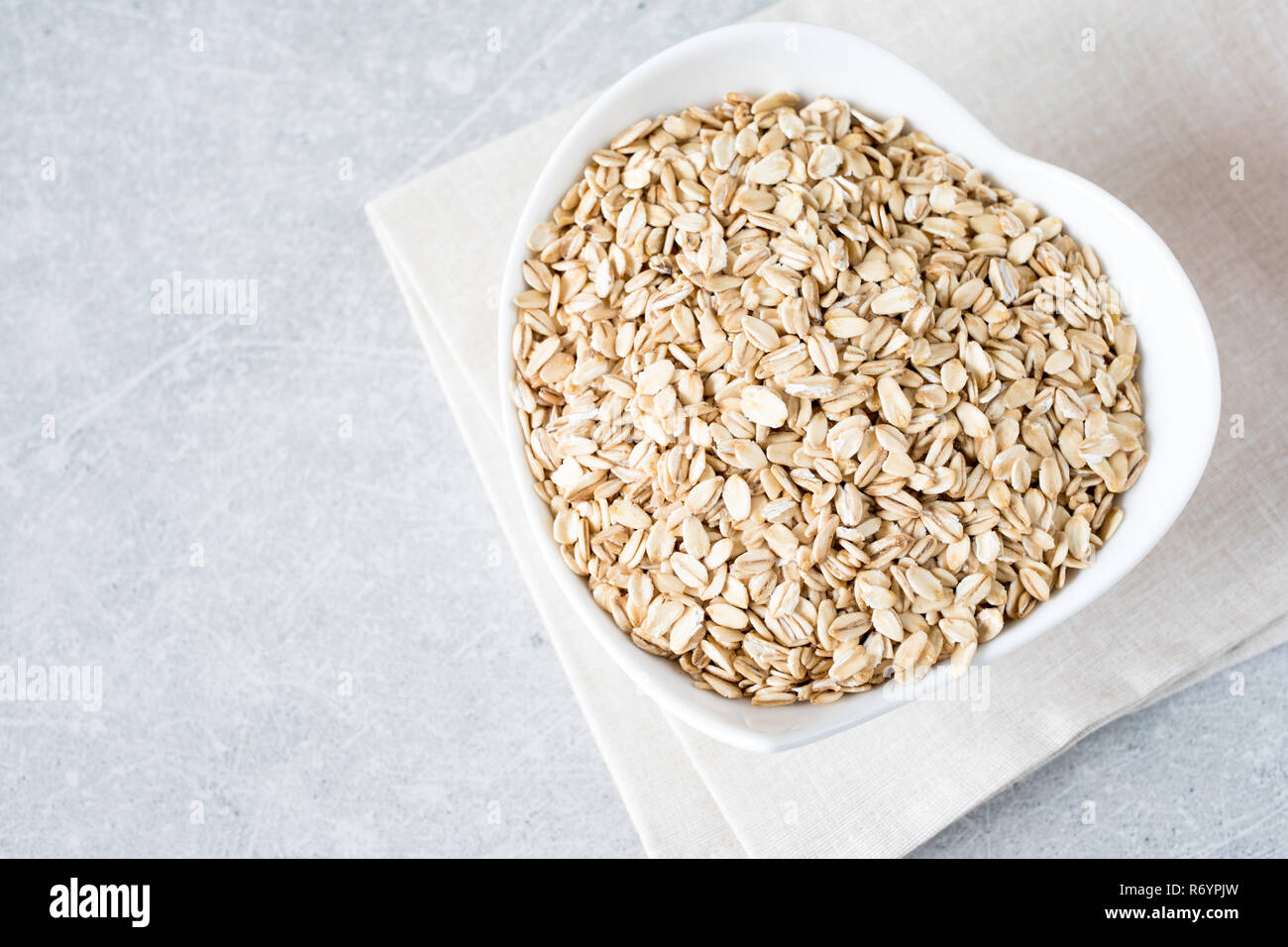 Food. Dry rolled oat flakes oatmeal on bowl. Healthy eating concept