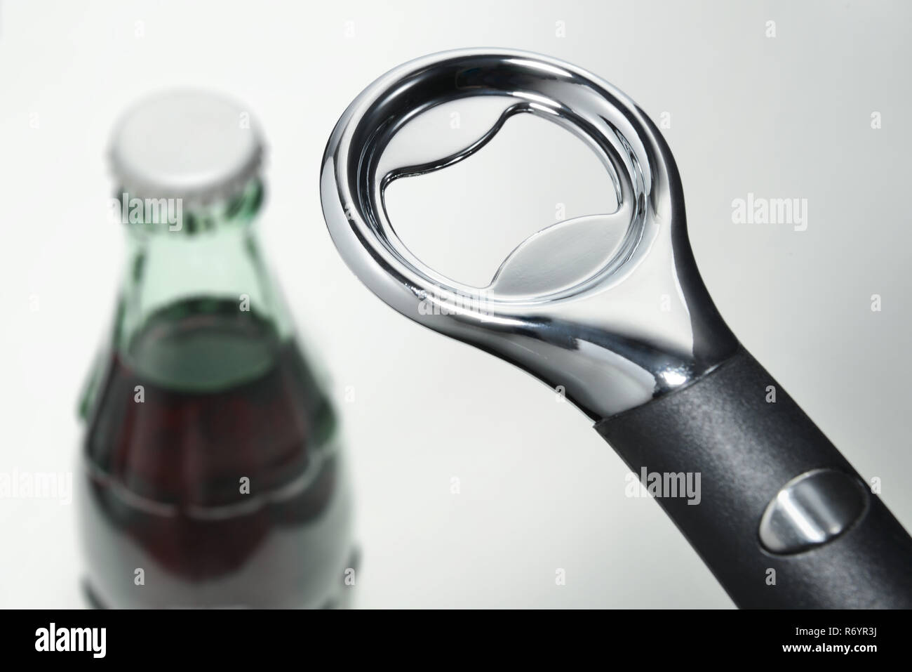 A bottle cap opener against a drink bottle background Stock Photo