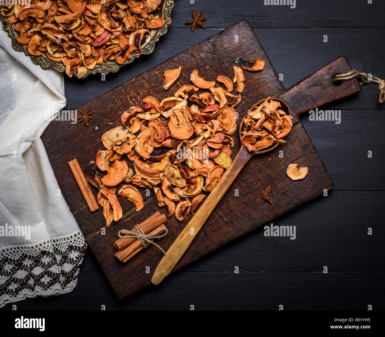 Dried pieces of apples in an iron plate and on a brown wooden board Stock Photo