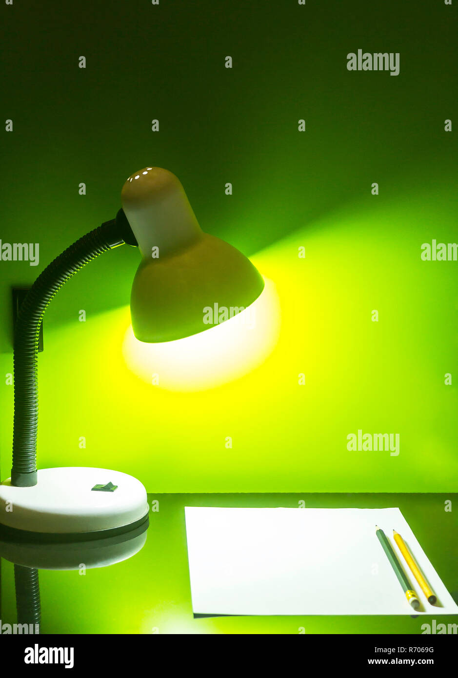 Lamp and paper with pencil on green wall Stock Photo - Alamy