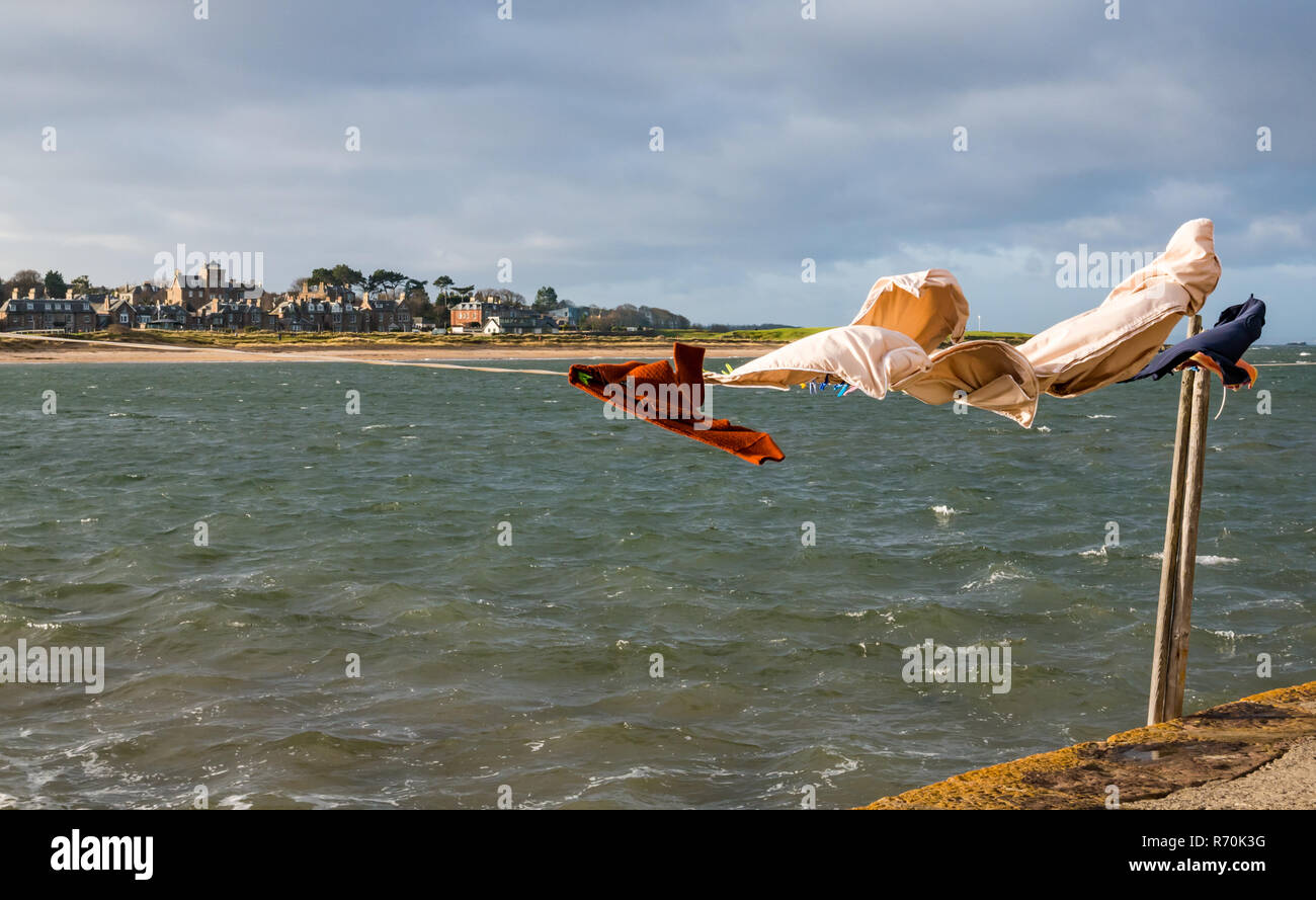 North Berwick, East Lothian, Scotland, United Kingdom. 7th December 2018. UK Weather: A bright sunny but very windy day in the seaside town with washing hanging on a line blowing in the wind in West Bay on the Firth of Forth shore Stock Photo