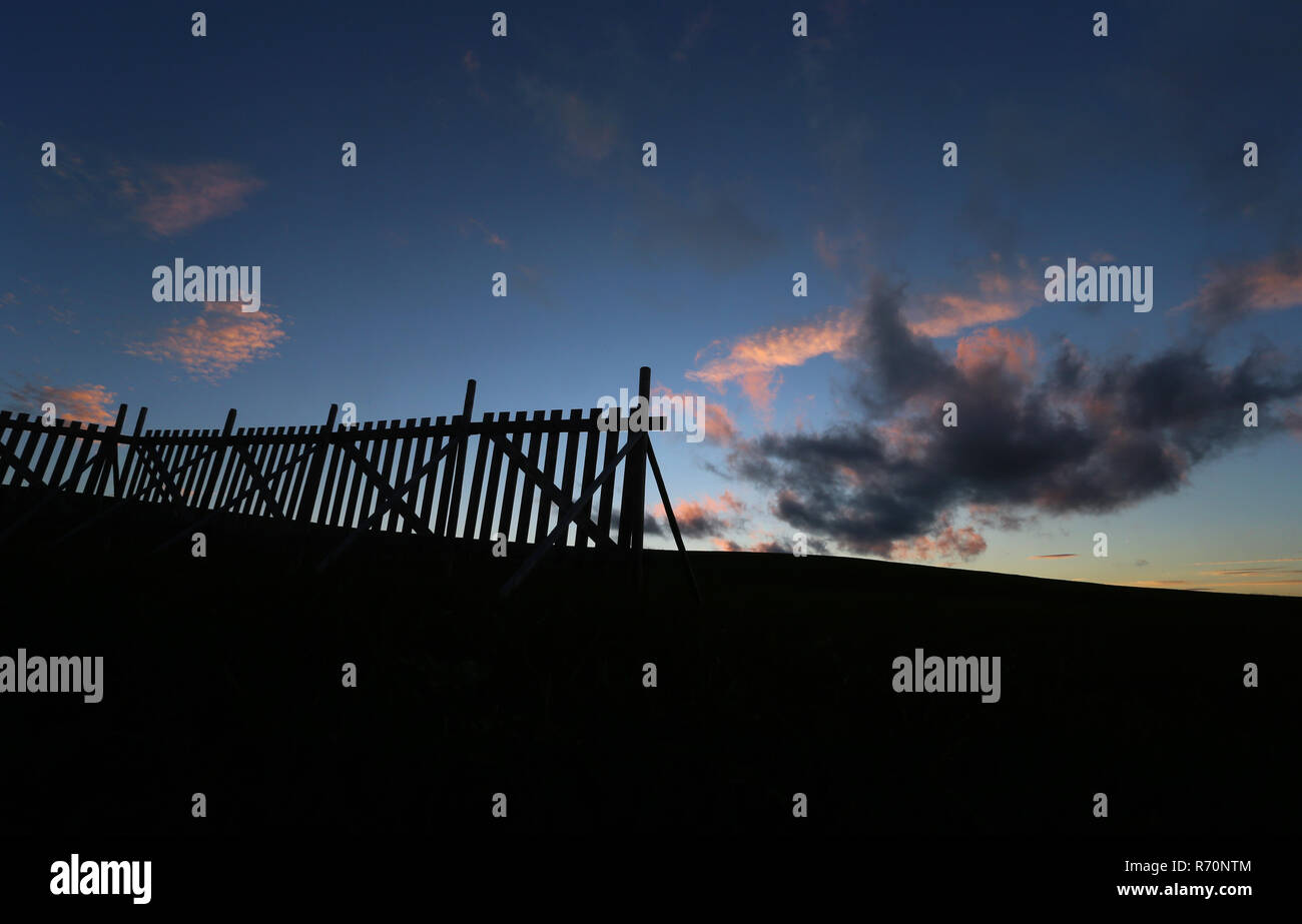 Betzigau, Germany. 07th Dec, 2018. Clouds shine in the light of the setting sun over the Allgäu landscape behind a snow fence. Credit: Karl-Josef Hildenbrand/dpa/Alamy Live News Stock Photo