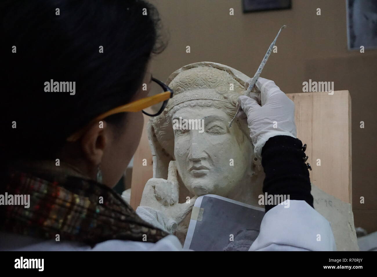 (181207) -- DAMASCUS, Dec. 7, 2018 (Xinhua) -- Heba Jouma, a conservator-restorer from the ancient city of Palmyra in Syria and a member of a Syrian restoration experts' team, works at the National Museum of Damascus in Damascus, Syria, on Dec. 5, 2018. Heba Jouma works to bring back ancient features to the sculptures damaged by the Islamic State (IS) group. The IS group had stormed Palmyra twice during the more than seven-year-long war, destroying precious archeological sites, such as temples and tombs, and shattering sculptures into pieces in the ancient oasis city, which is registered by th Stock Photo