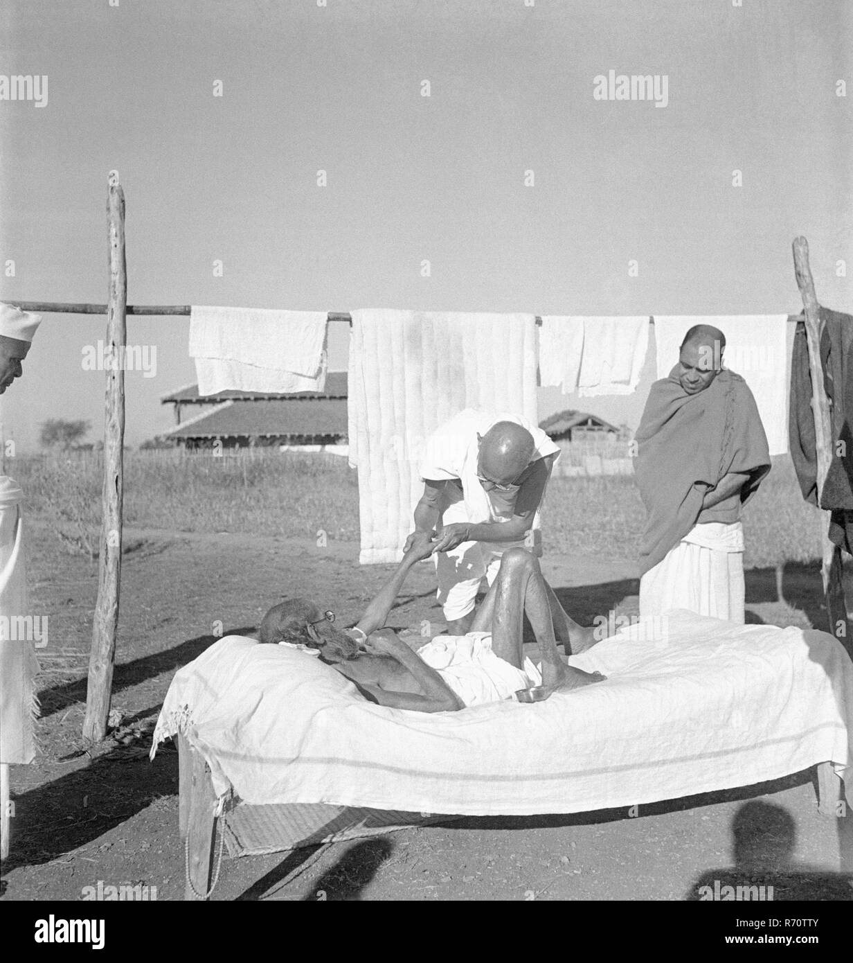 Mahatma Gandhi giving massage to a leper patient at Sevagram Ashram, Wardha, Maharashtra, India, 1940, old vintage 1900s picture Stock Photo
