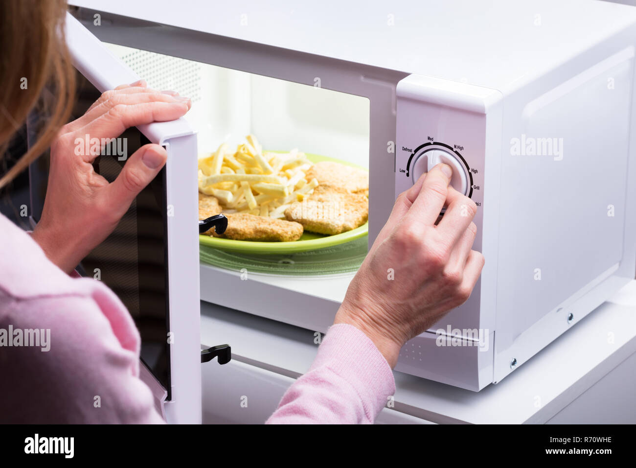 https://c8.alamy.com/comp/R70WHE/woman-heating-food-in-microwave-R70WHE.jpg
